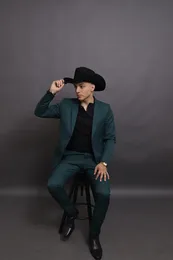 Alonso Guezt sentado, tocando el ala del sombrero y mirando a un lado